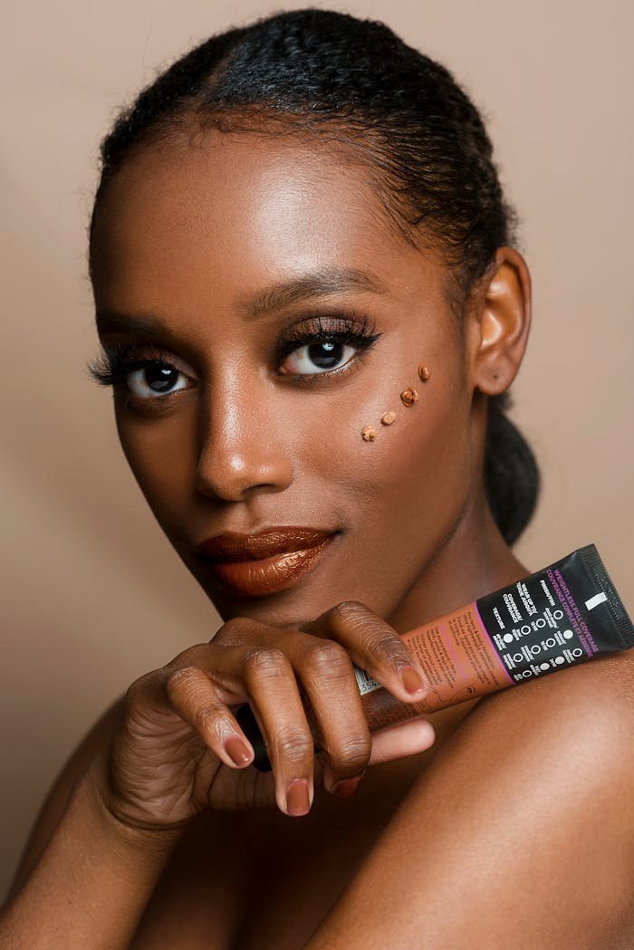 Elegant portrait of a woman showcasing skincare product with flawless makeup and glowing skin.